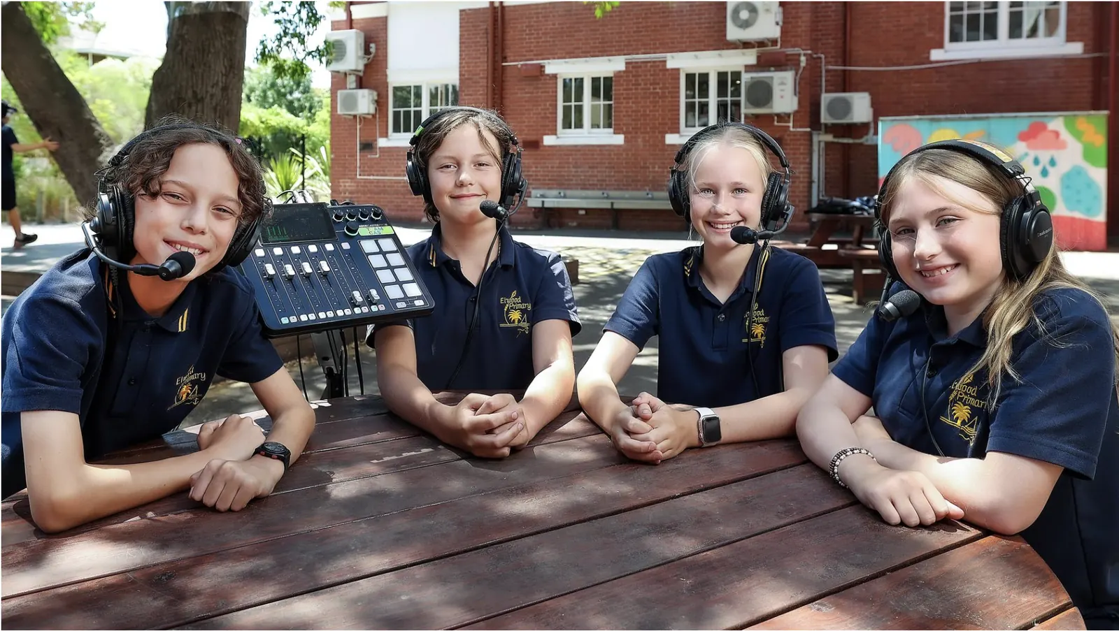 Students from Elwood Primary School recording an episode of Elwood on Air around a picnic table